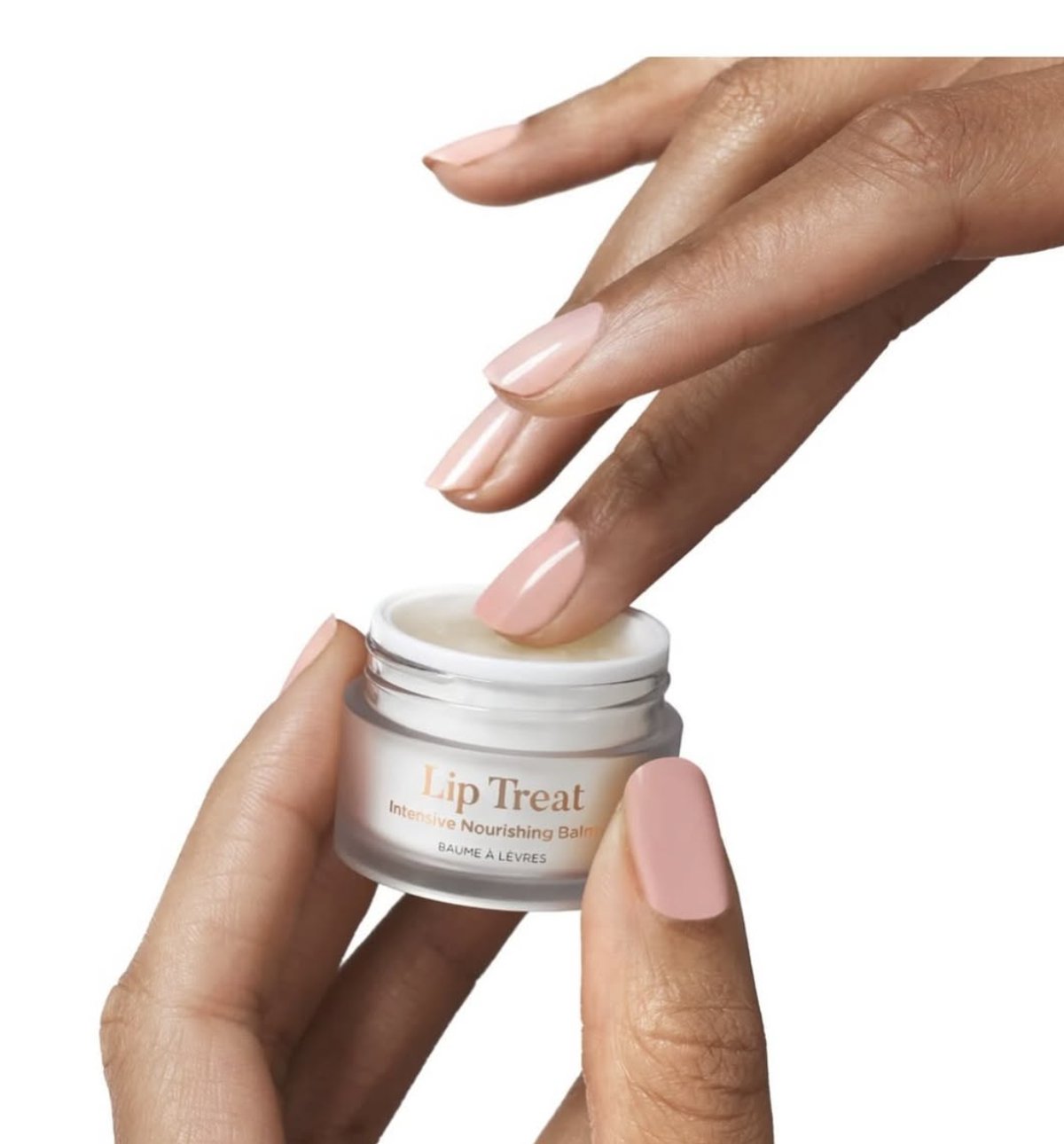 Hand applying Lip Treat intensive nourishing balm